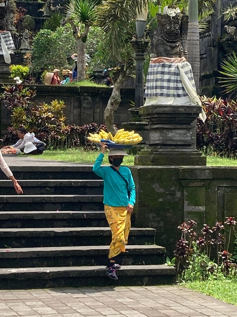       Local vendor carrying fruit basket on head.
  