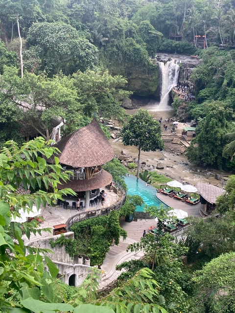       Rustic restaurant with pool and waterfall view.
  