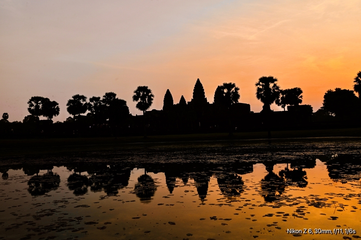       Silhouette of Angkor Wat temple against sunrise.
  