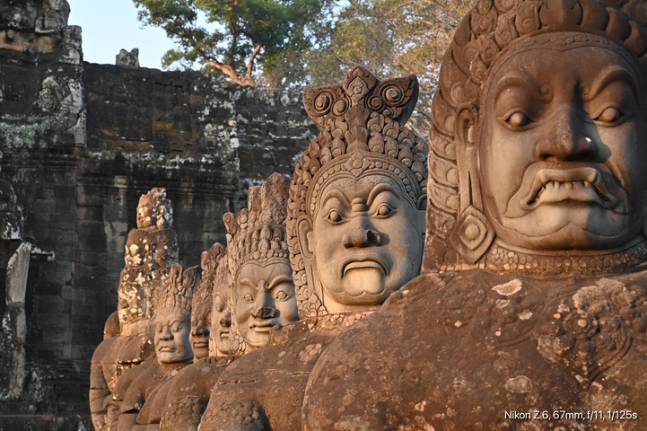 Row of ancient stone statues with detailed carvings.