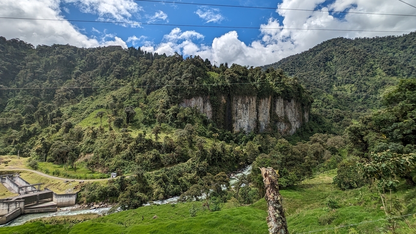       Lush greenery and a river in a mountainous area.
  