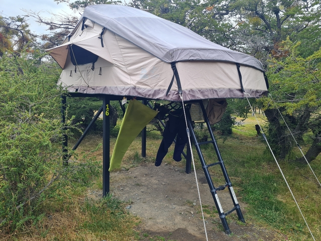 Elevated tent set up in a wooded area.