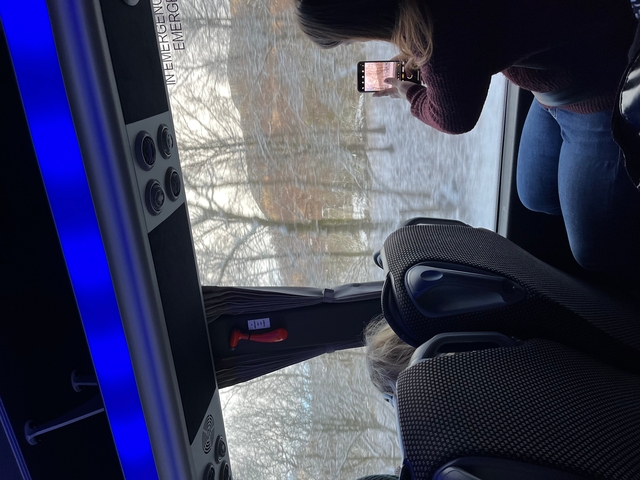 View from inside a bus with people looking out.