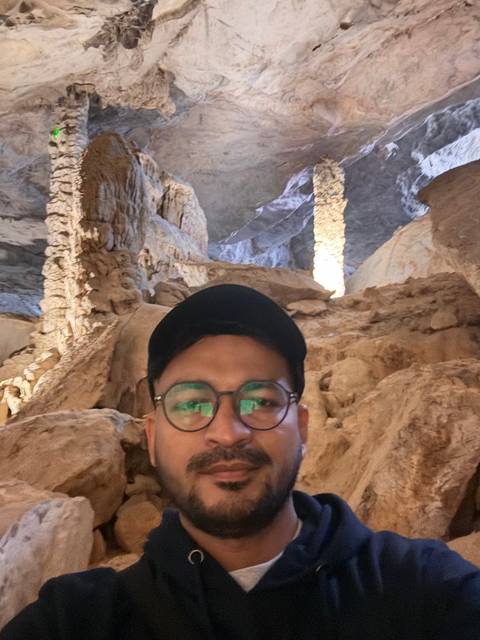       Upside-down image of a person in a cave.
  