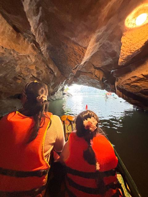       Upside-down image of people in a cave on boats.
  
