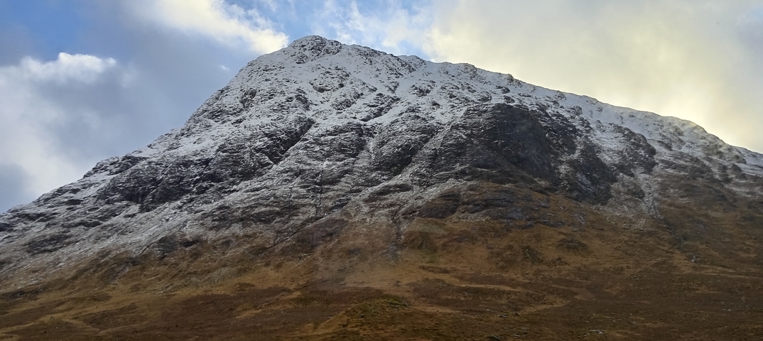       Snow-capped mountain landscape with a cloudy sky.
  