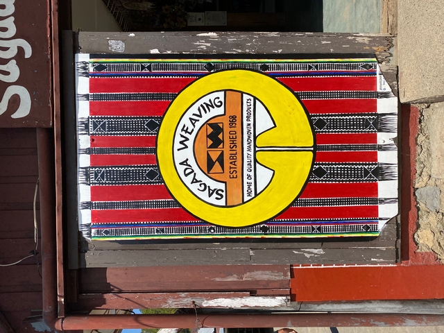 Sign for Sagada weaving against a patterned background.