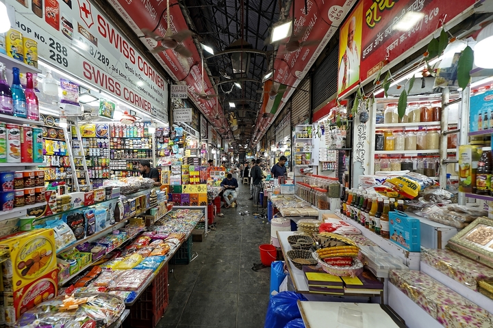       Busy market scene with various colorful goods.
  