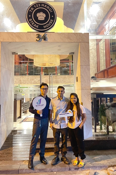 Three people posing with travel experience signs.