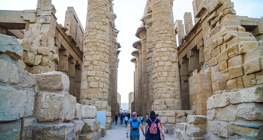       Tourists walking through ancient columns.
  