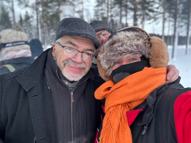       People posing in winter clothing in a snowy setting.
  