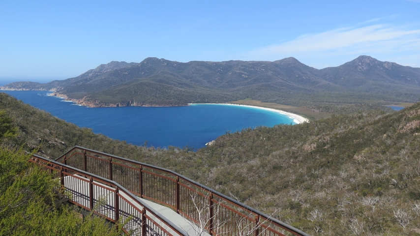 Observation deck overlooking a bay surrounded by mountains.