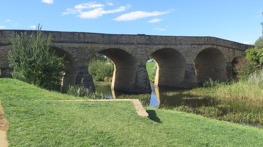 Historic stone bridge over a calm river.