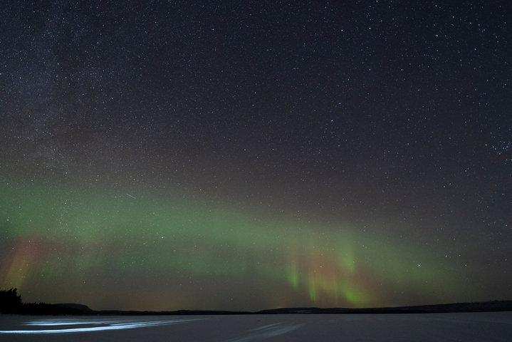 Aurora Borealis in the night sky with stars visible.