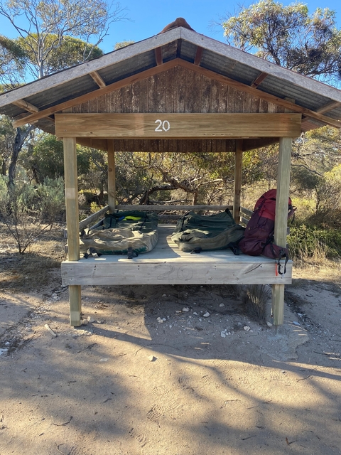 Outdoor sleeping platform with camping gear.