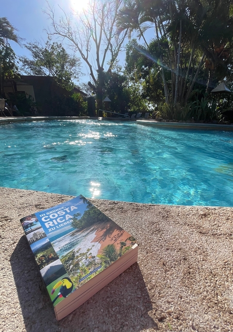       Pool with reflections, and a book with 'Costa Rica' text.
  