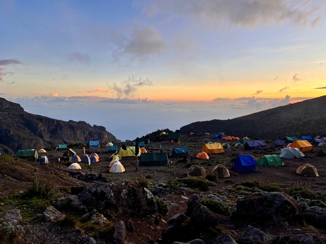 Tents in a mountain campsite at sunset.