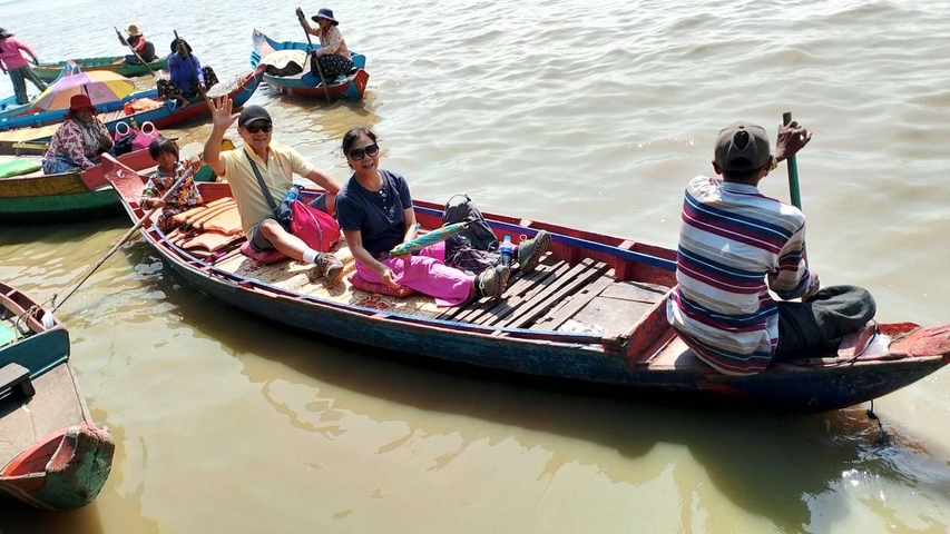 People in small boats on a lake under the bright sun.