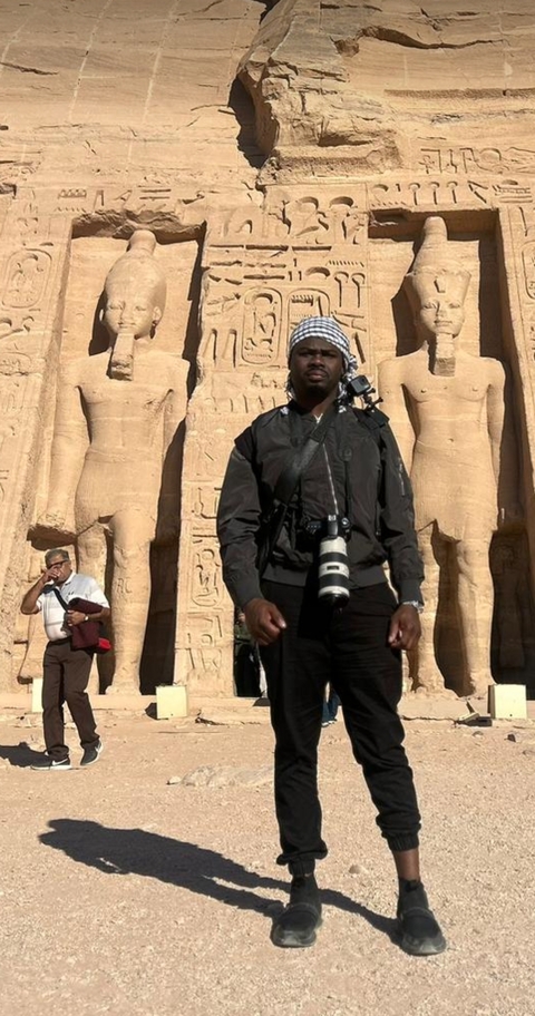       Person standing in front of ancient Egyptian statues.
  