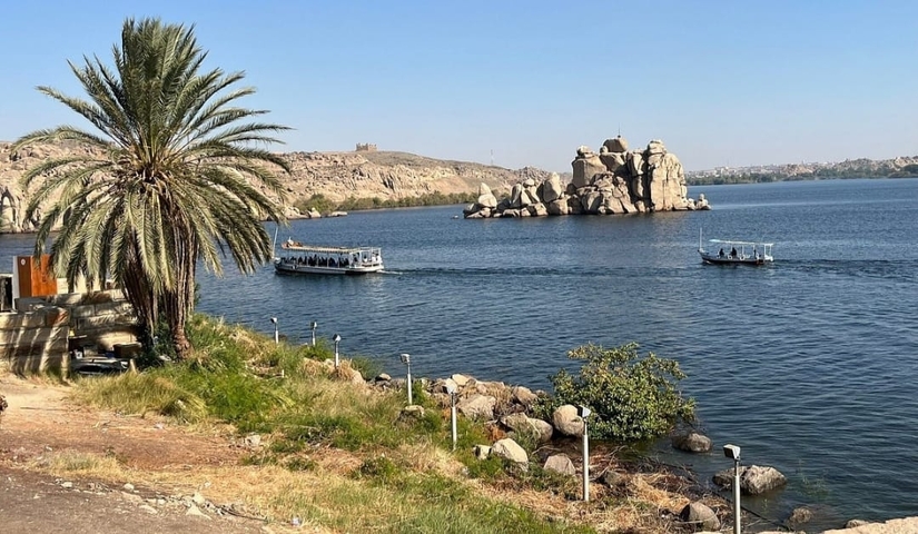 River scene with boats and rocky monoliths.