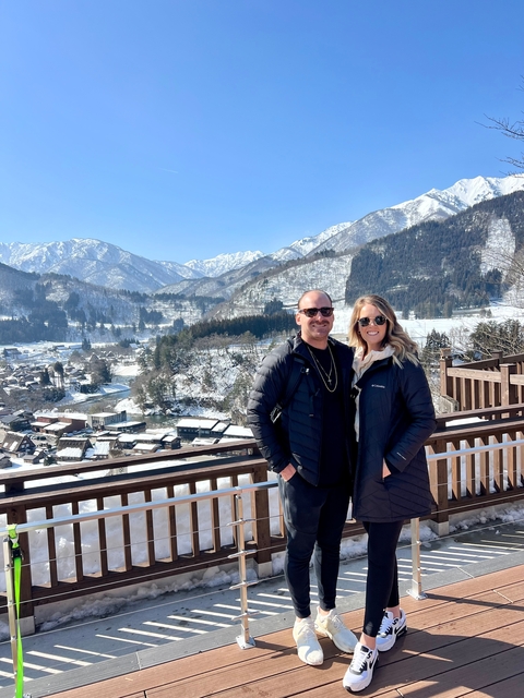 Couple posing with snow-covered mountains.