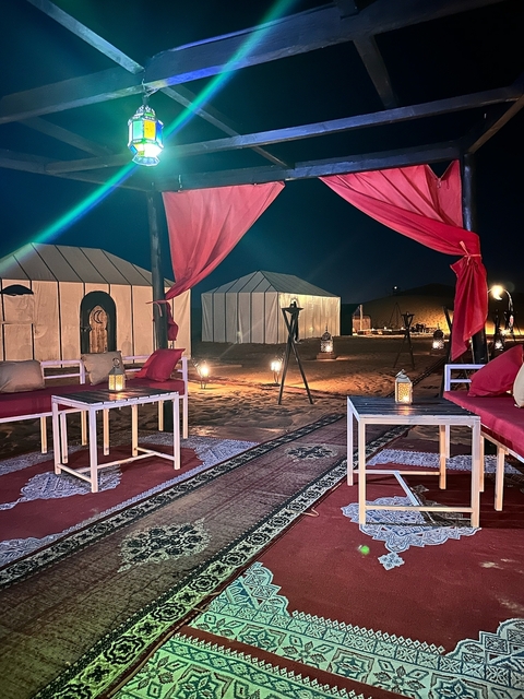 Desert camp at night with red drapery.