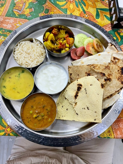 A traditional Indian thali meal with various dishes.