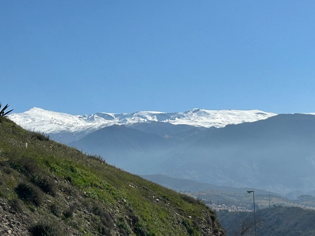 Snow-covered mountains under clear blue sky.