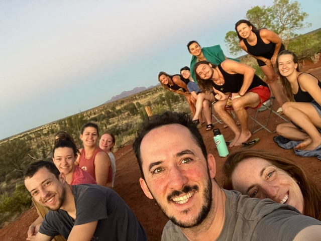 Group selfie with outback landscape.