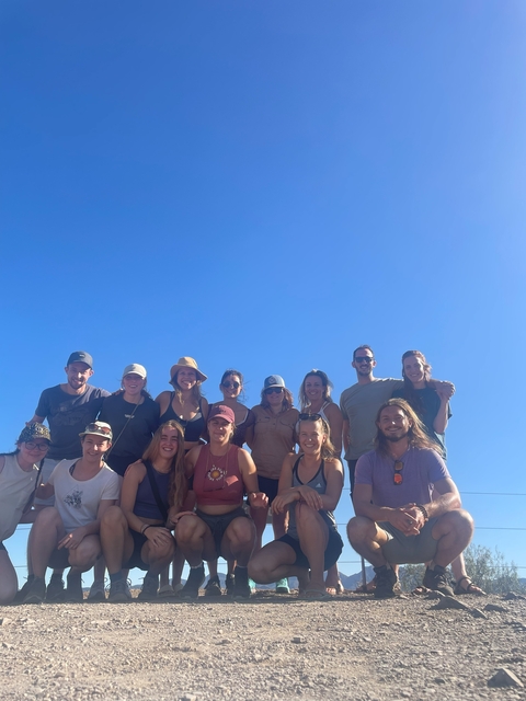 Group photo of hikers under a blue sky.