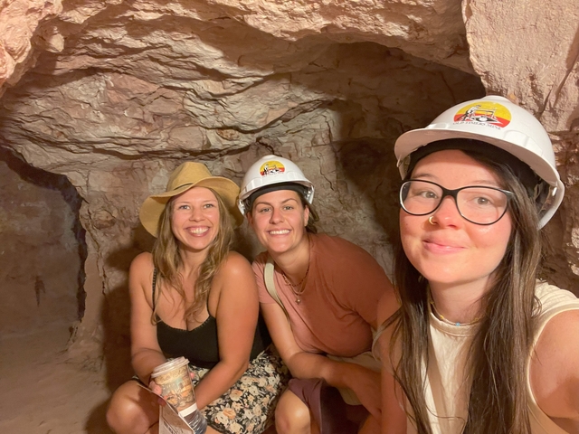      Three women posing inside a cave.
  