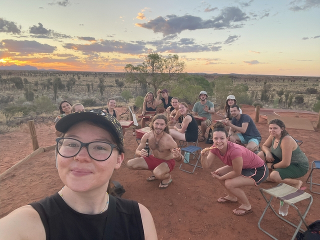 Group of people enjoying a picnic during sunset in the outback.