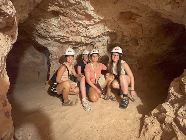       Group of people in a cave wearing helmets.
  