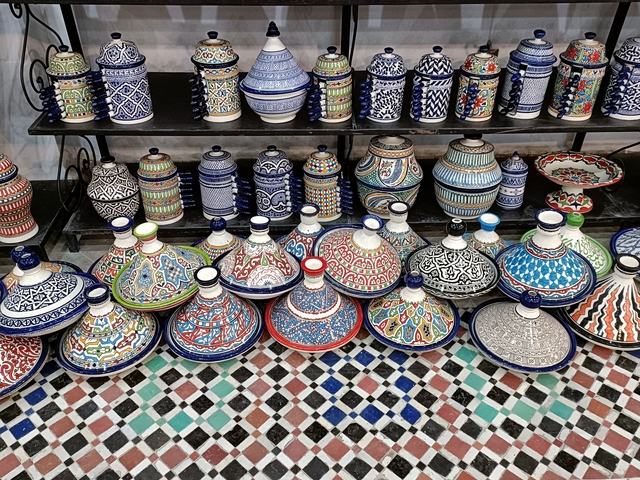       Colorful Moroccan pottery displayed on shelves.
  