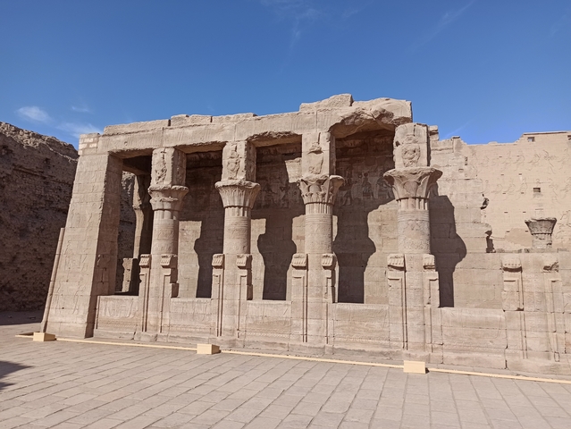 Ancient temple with columns and blue sky.