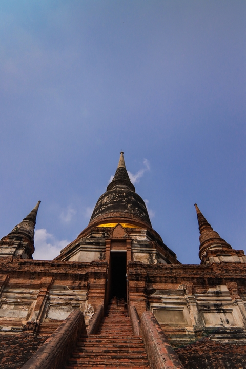       Several tall, pointed stupas from below, against a blue sky
  