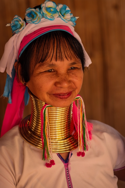       Smiling woman wearing traditional attire with neck rings
  