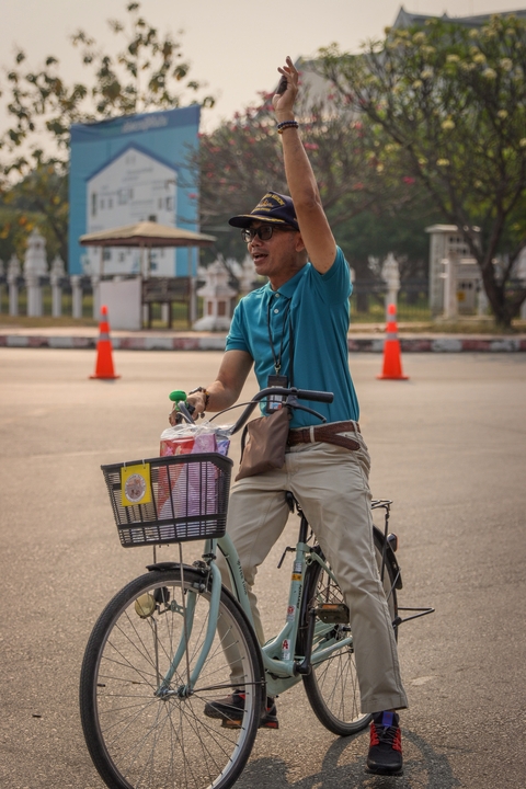      Man riding a bicycle with a basket filled with bags
  