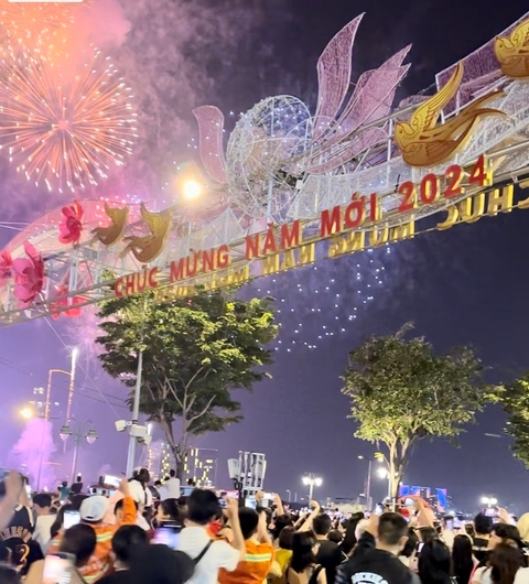 Firework display over a decorated street with New Year signs.