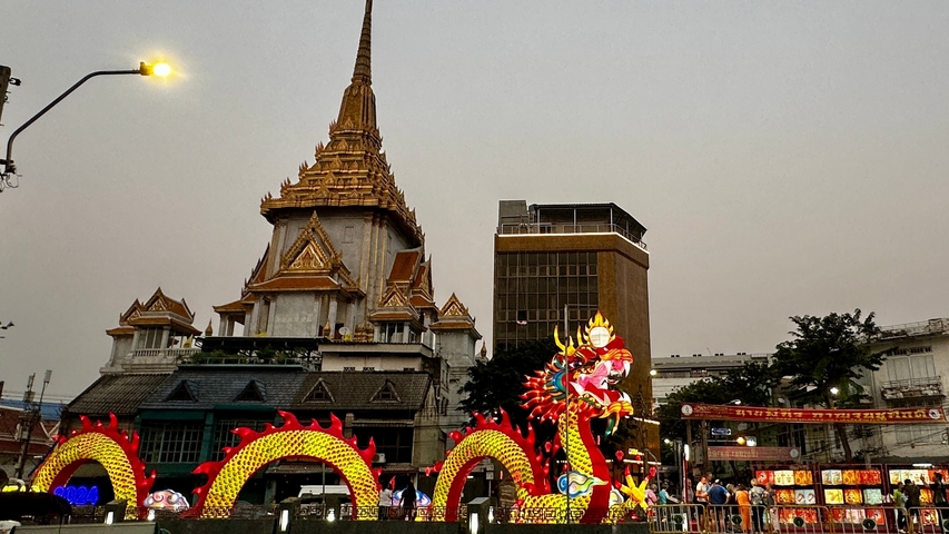       Temple with a dragon sculpture during dusk, lit up with lights.
  