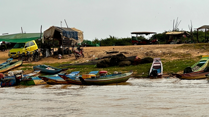       Boats docked at a riverbank with a rustic setting.
  