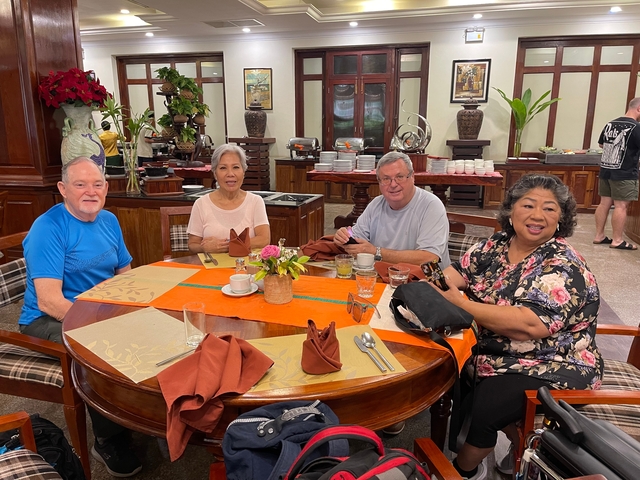       Four people enjoying a meal in a restaurant.
  