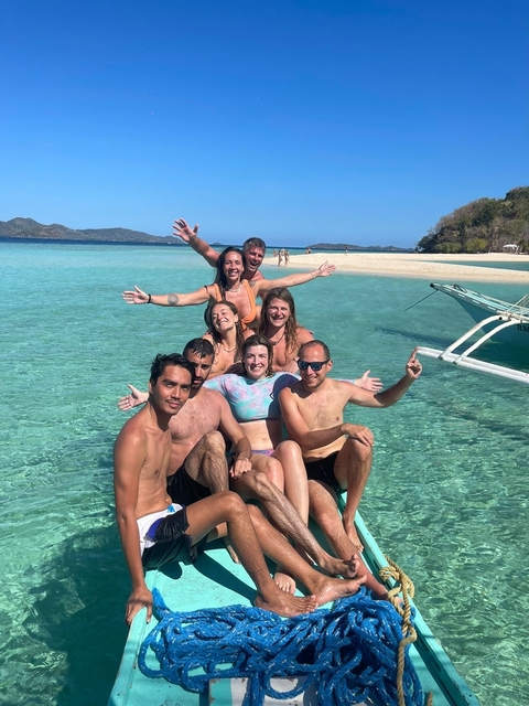Group of people enjoying the beach and clear water.
