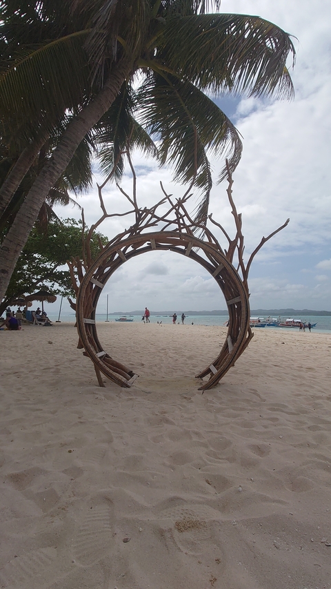       Circular wooden structure facing a beach.
  