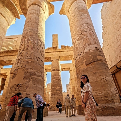 Person among ancient temple columns.