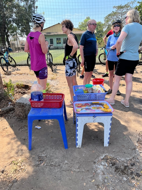 Close-up of legs and some food items on small tables.