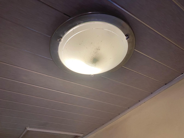       Ceiling light fixture emitting dim light.
  