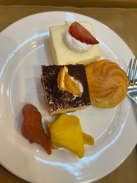       A plate with an assortment of desserts including a chocolate cake slice.
  