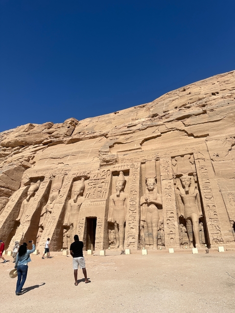Ancient Egyptian temple with hieroglyphs and statues.