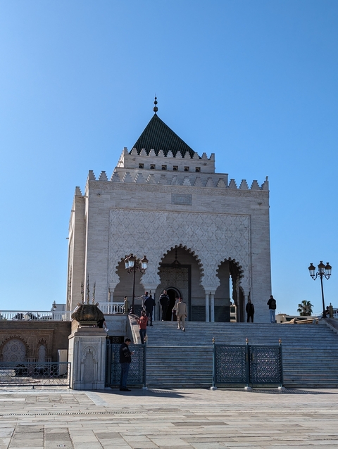       Mausoleum or historical building with people outside.
  